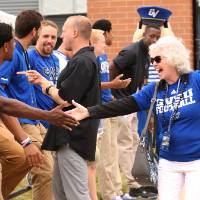 Marcia Haas giving a high-five to a guest at the Jamie Hosford Football Center dedication.